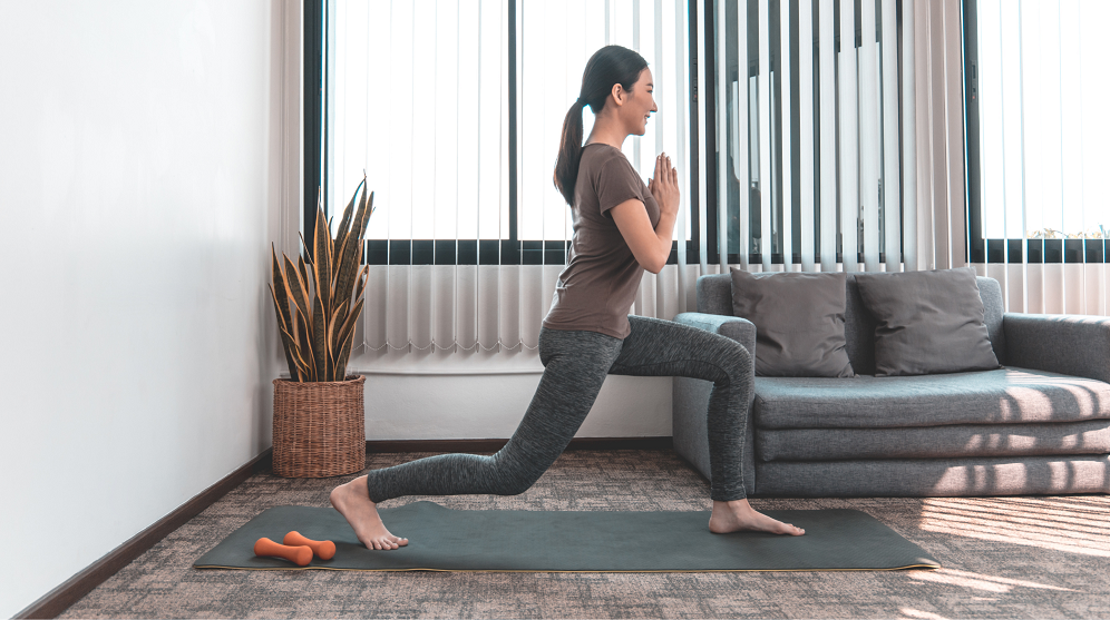 Young Woman Exercising At Home Doing Lunges 